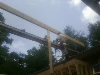Carpenter setting a ridge beam over a new addition frame — Ice Dam Removal by Roofing Brothers in Skyforest