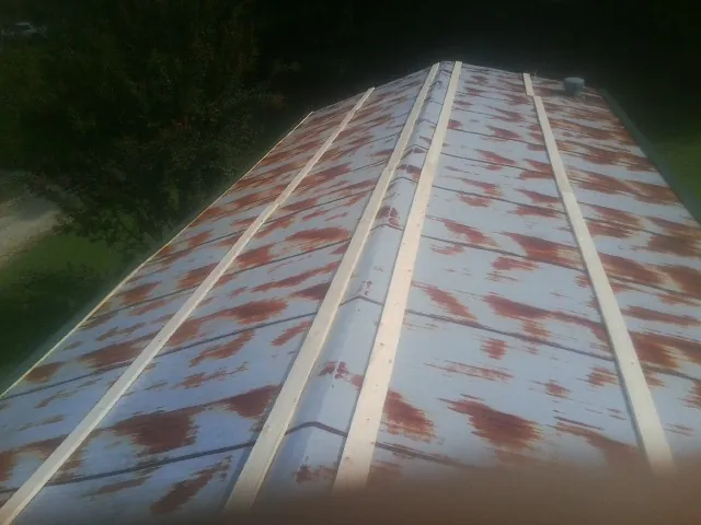 Rusted metal roof panels with new wood purlins before replacement — Storm Damage Roof Repair in Skyforest by Roofing Brothers