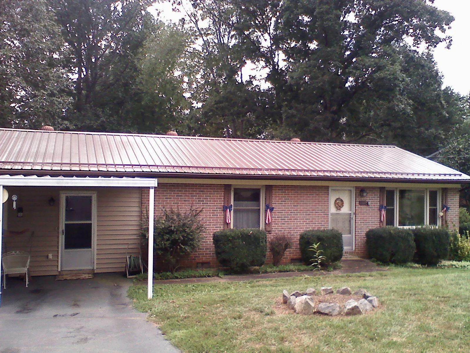 Bronze metal roof and carport on a brick ranch home — Roof Repair work by our crew in Skyforest