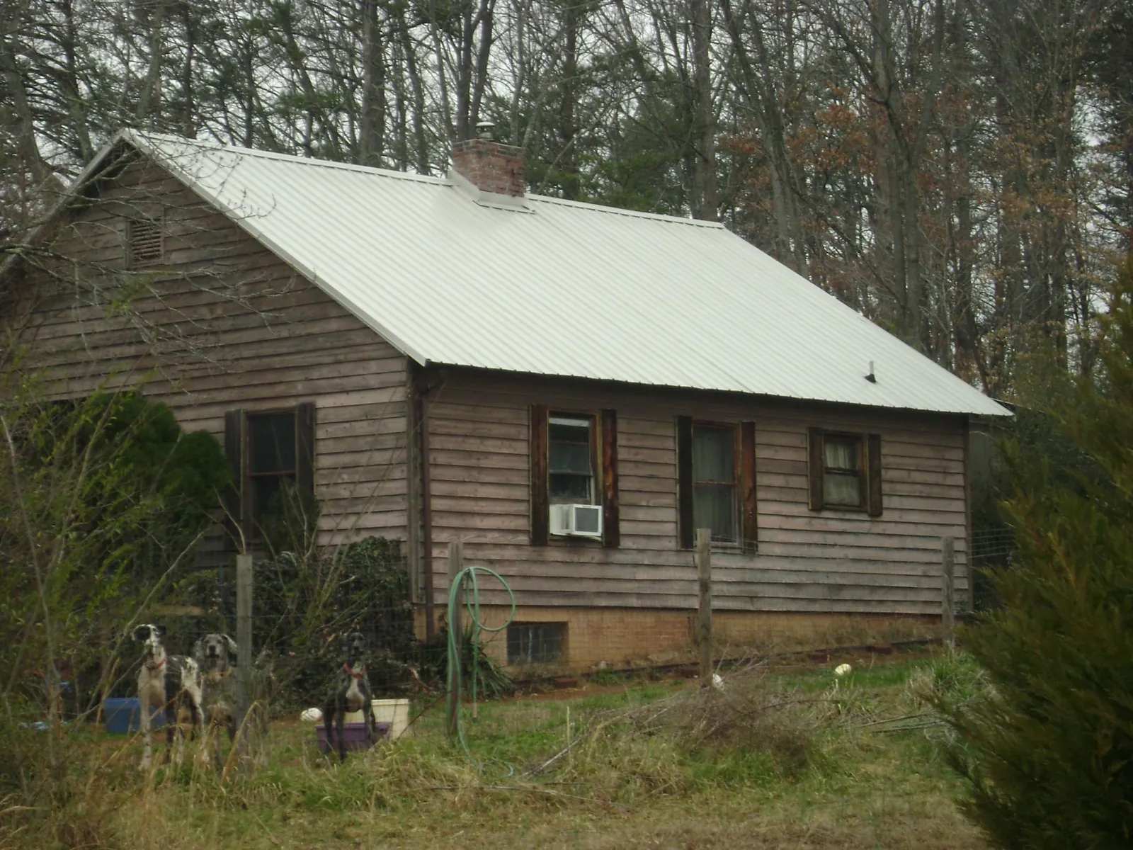 White metal roof on an old wood sided farmhouse, from a Metal Roof Installation job in Skyforest